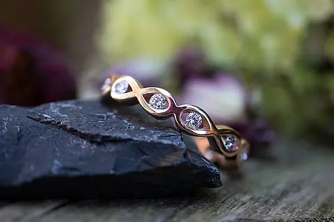 Infinity Verlobungsring aus Rotgold mit Steinen (Brillanten). Die Steinanzahl kann individuell bestimmt werden. Der Infinity Verlobungsring kann natürlich auch als Vorsteckring getragen werden.