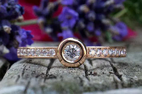 Besonderer Verlobungsring mit einem großen und vielen kleinen Steinen (Brillanten) aus Rotgold. Auch tragbar als Vorsteckring